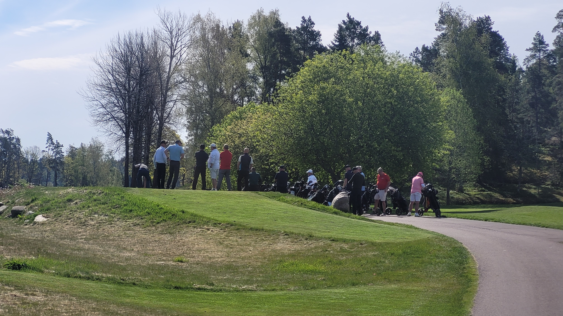 Ett golfgäng samlas mellan hålen under en tourdag